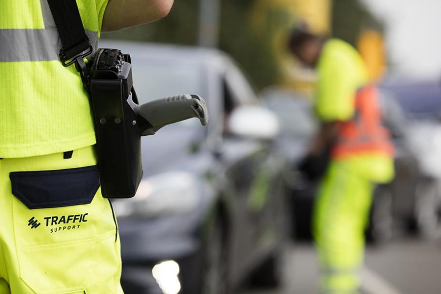 Traffic Support broek met op de achtergrond werknemer die auto helpt